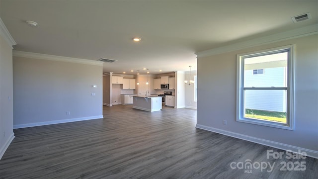 unfurnished living room featuring a chandelier, crown molding, dark hardwood / wood-style flooring, and sink