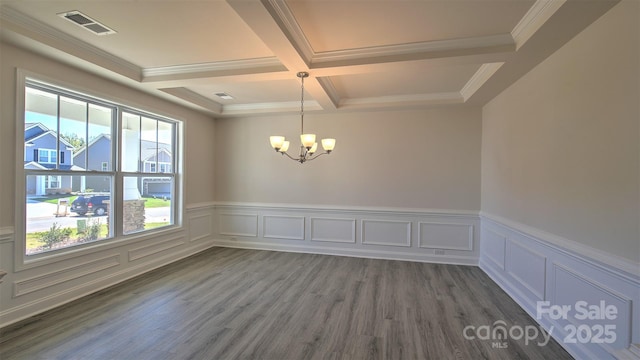 unfurnished room with coffered ceiling, a chandelier, plenty of natural light, and beamed ceiling