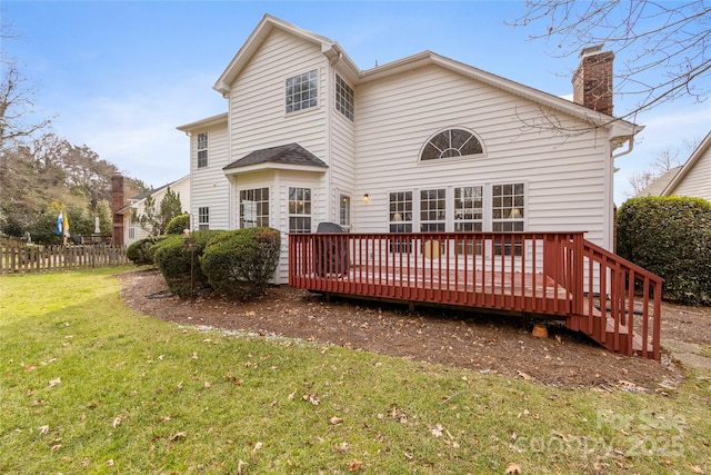 back of house with a lawn and a deck