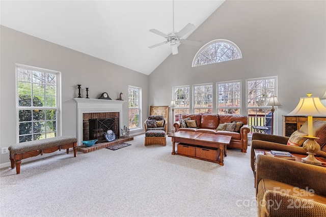 carpeted living room featuring ceiling fan, high vaulted ceiling, and a fireplace