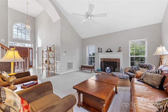 living room featuring light colored carpet, a fireplace, high vaulted ceiling, and a wealth of natural light