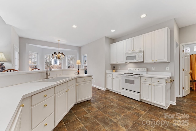 kitchen with white cabinetry, sink, hanging light fixtures, white appliances, and an inviting chandelier