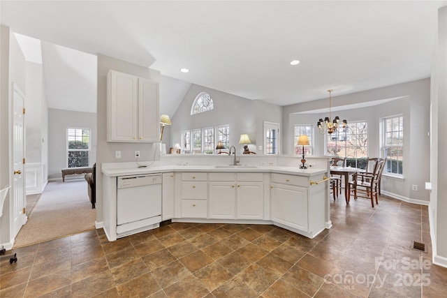 kitchen with sink, dishwasher, an inviting chandelier, hanging light fixtures, and white cabinets