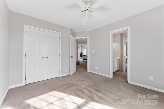 unfurnished bedroom with light carpet, a closet, ceiling fan, and ensuite bathroom