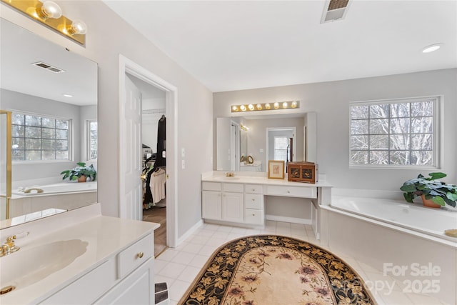 bathroom featuring vanity, tile patterned flooring, a bathtub, and plenty of natural light