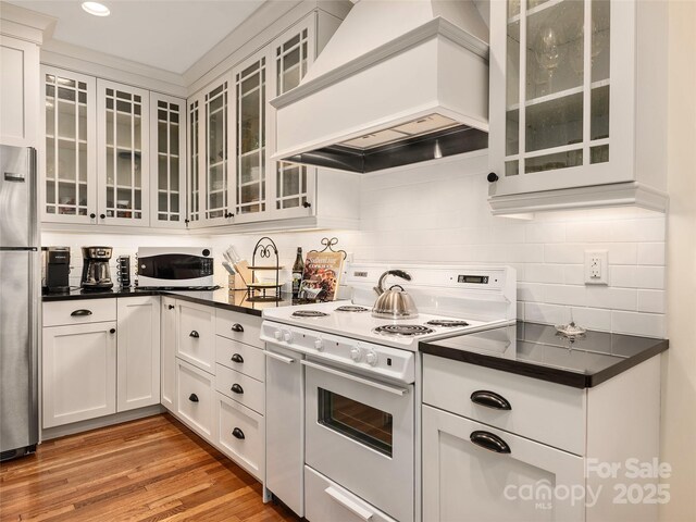 203 6th Ave W Unit 1B, Hendersonville, NC 28739 - kitchen featuring white appliances, custom range hood, dark countertops, white cabinetry, and recessed lighting
