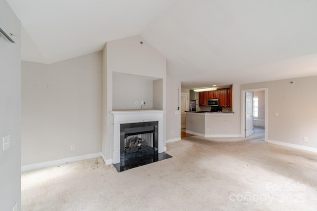 unfurnished living room with light carpet and lofted ceiling