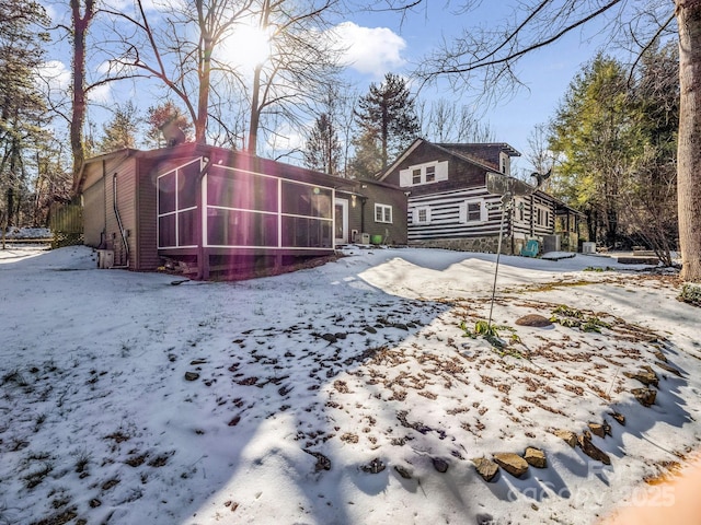 snow covered property with a sunroom