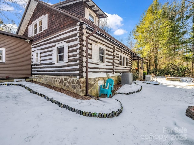 view of snowy exterior featuring ac unit and central AC