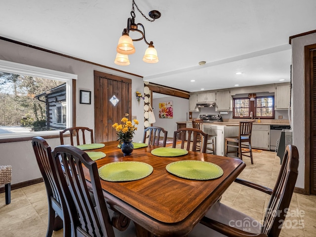 dining space featuring sink and ornamental molding