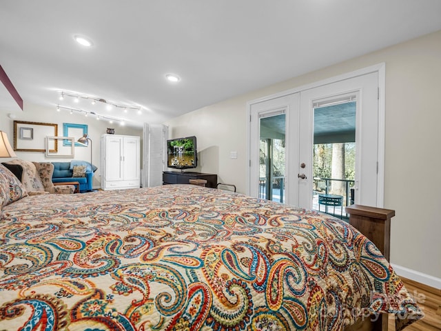 bedroom featuring french doors, access to exterior, hardwood / wood-style floors, and rail lighting