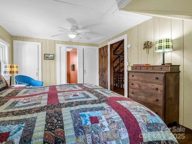 bedroom featuring wooden walls and ceiling fan