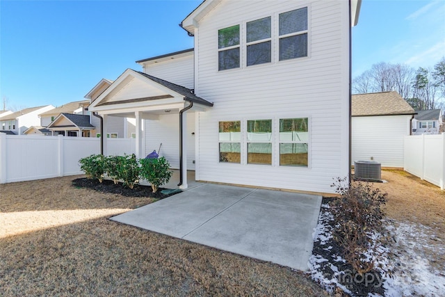 rear view of house with central AC unit and a patio area