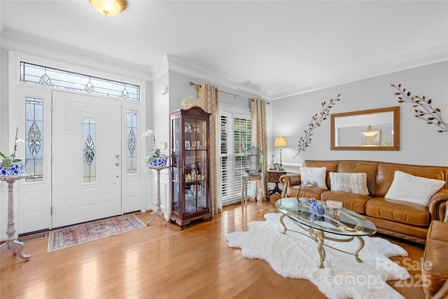 entryway with ornamental molding and light hardwood / wood-style flooring