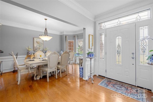 foyer entrance featuring ornamental molding and light hardwood / wood-style flooring