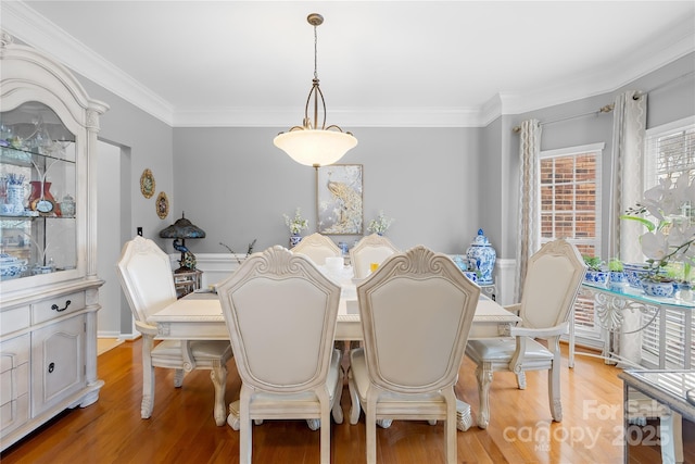 dining space with crown molding and light hardwood / wood-style floors