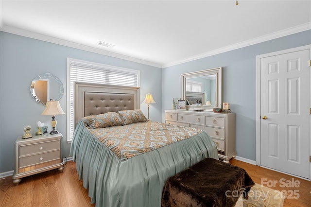 bedroom featuring multiple windows, hardwood / wood-style floors, and crown molding