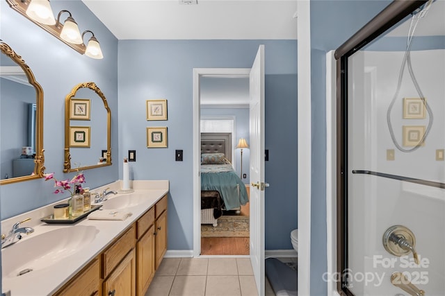 bathroom featuring vanity, toilet, an enclosed shower, and tile patterned flooring