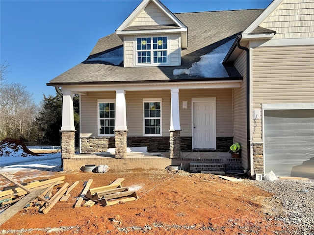 view of front of property featuring covered porch and a garage