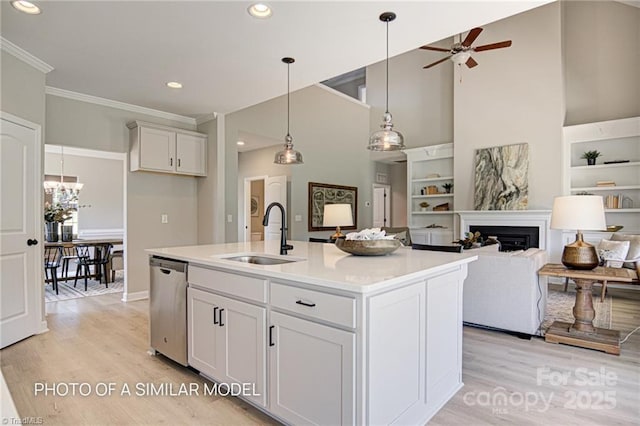 kitchen featuring dishwasher, a center island with sink, sink, built in features, and white cabinets