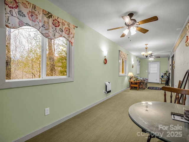 carpeted dining area with ceiling fan with notable chandelier and heating unit