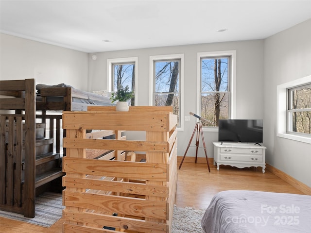 bedroom with multiple windows and light wood-type flooring