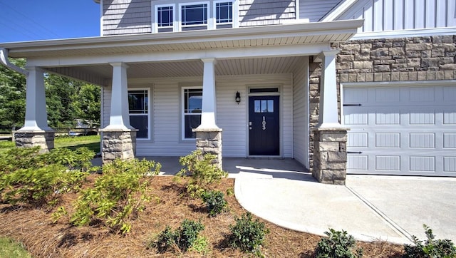 doorway to property with a garage and a porch