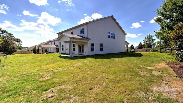 back of property with a lawn and a patio area