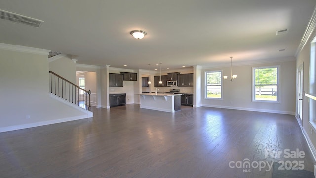 unfurnished living room featuring sink, a chandelier, ornamental molding, and dark hardwood / wood-style floors