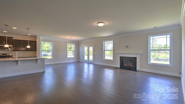 unfurnished living room with ornamental molding, dark wood-type flooring, and a healthy amount of sunlight