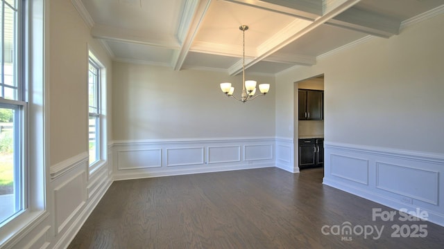 spare room with dark wood-type flooring, a notable chandelier, beam ceiling, crown molding, and coffered ceiling