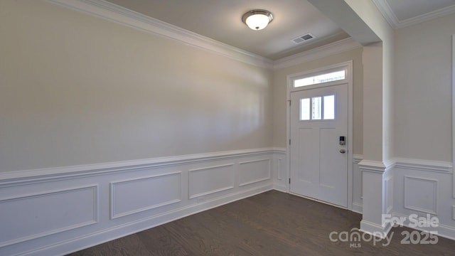 foyer entrance with ornamental molding and dark hardwood / wood-style flooring