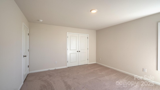 unfurnished bedroom with a closet and carpet flooring