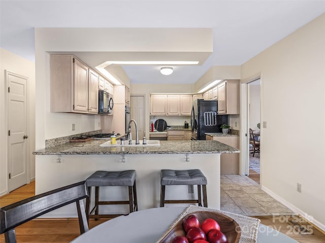 10 Clubside Dr, Asheville, NC 28804 - kitchen featuring a sink, freestanding refrigerator, a kitchen breakfast bar, a peninsula, and light stone countertops