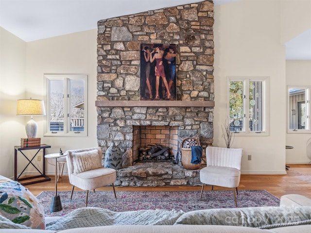 living room featuring hardwood / wood-style flooring, vaulted ceiling, and a fireplace