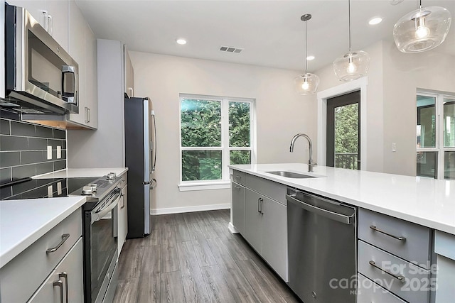 kitchen with sink, pendant lighting, appliances with stainless steel finishes, and gray cabinets