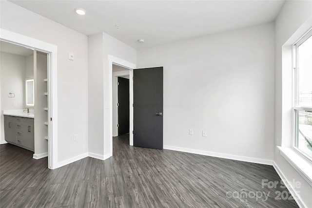 unfurnished bedroom with dark wood-type flooring and ensuite bath