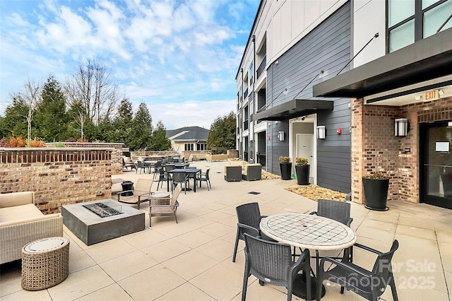 view of patio featuring an outdoor living space with a fire pit