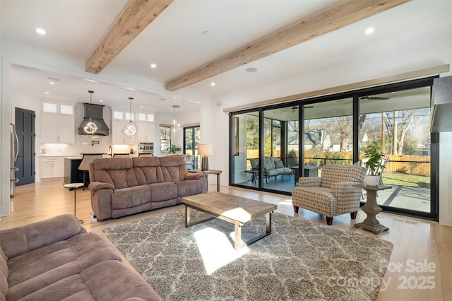 living room featuring light hardwood / wood-style floors and beam ceiling