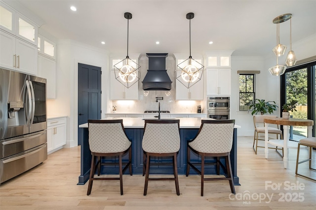 kitchen featuring custom exhaust hood, white cabinets, and stainless steel appliances