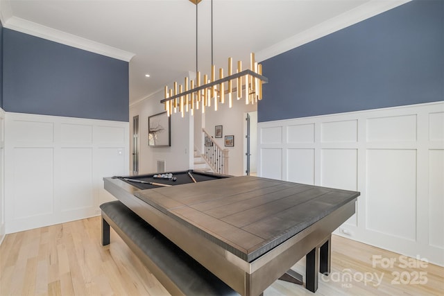 dining area featuring billiards, light wood-type flooring, and crown molding