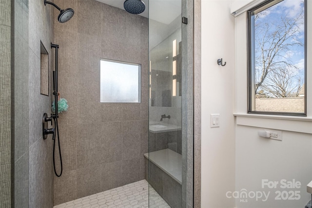 bathroom with a wealth of natural light and a tile shower