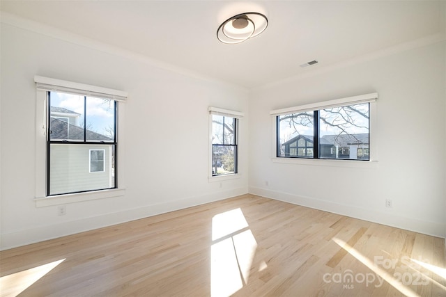 empty room featuring light hardwood / wood-style floors and ornamental molding