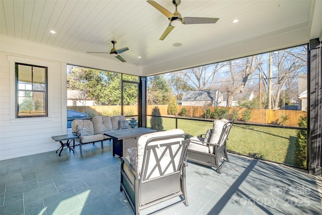 sunroom / solarium featuring ceiling fan, a healthy amount of sunlight, and wood ceiling