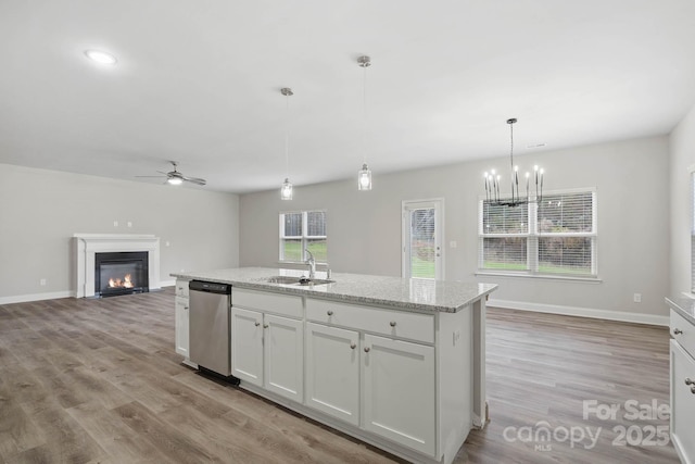 kitchen featuring stainless steel dishwasher, pendant lighting, a center island with sink, white cabinetry, and ceiling fan