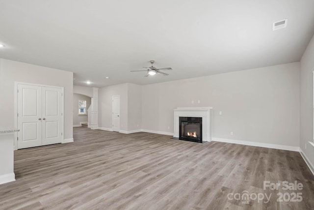 unfurnished living room featuring ceiling fan and light hardwood / wood-style floors