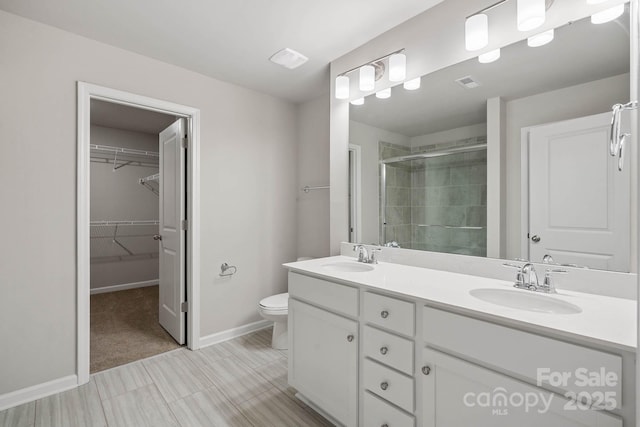 bathroom with toilet, walk in shower, and vanity