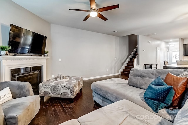 living room featuring ceiling fan and dark hardwood / wood-style flooring