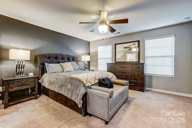 bedroom featuring ceiling fan, light colored carpet, and multiple windows