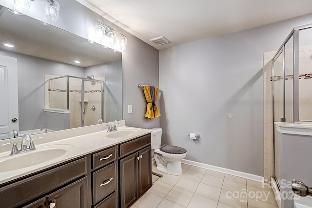 bathroom with walk in shower, vanity, tile patterned flooring, and toilet